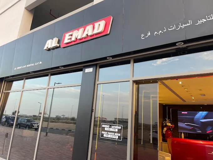 Car rental shopfront at AL Emad with modern signage and glass facade.