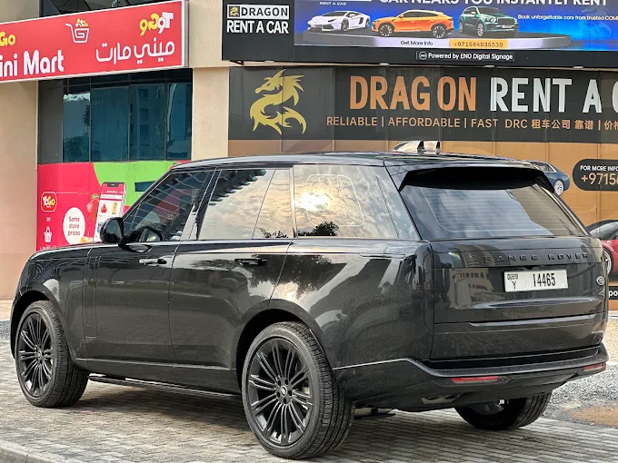 Black Range Rover SUV parked in front of UAE car rental shop.