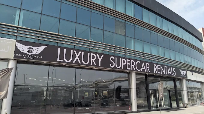 Luxury supercar rental shop in UAE with modern glass facade.