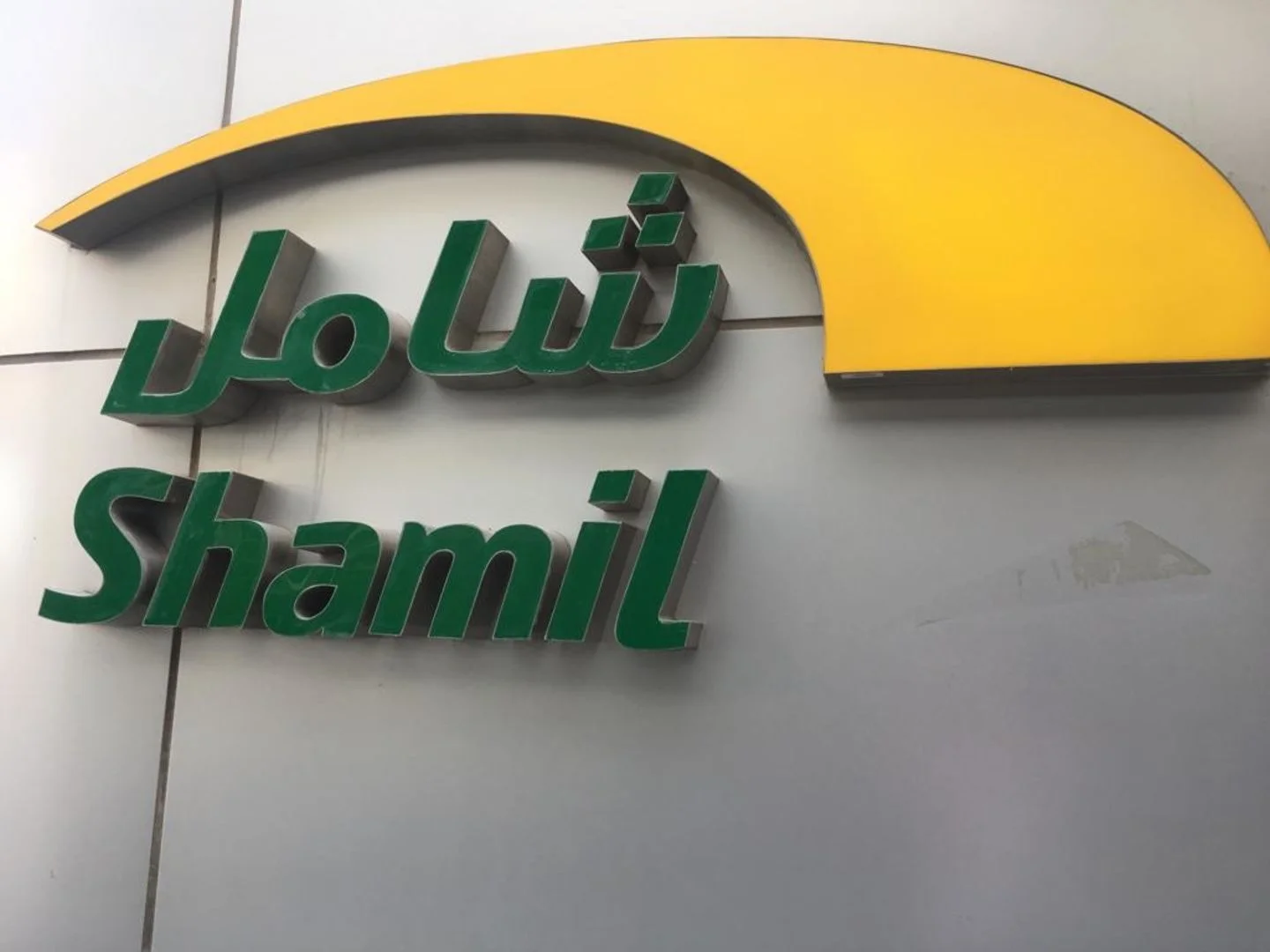 Shamil car dealership sign in UAE with logo and Arabic text.